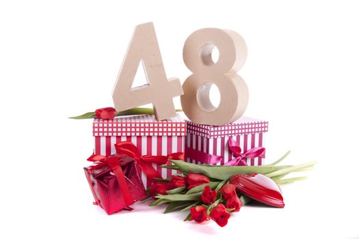 Number of age in a colorful studio setting with a red heart and gifts and tulips