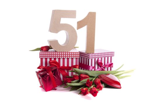 Number of age in a colorful studio setting with a red heart and gifts and tulips