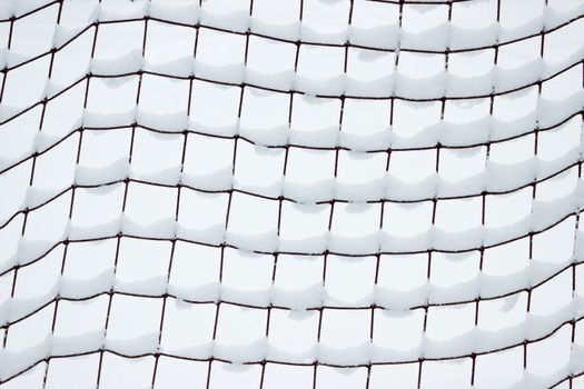 Football goal net, covered with snow in January