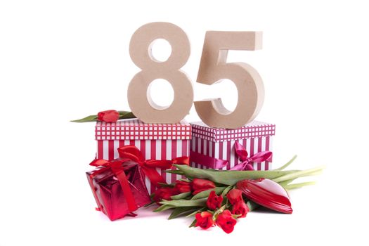 Number of age in a colorful studio setting with a red heart and gifts and tulips