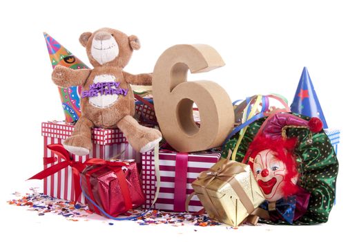 Number of age in a colorful studio setting with paper party hats, a red heart and gifts on a bottom of confetti for  childrens birthday party

