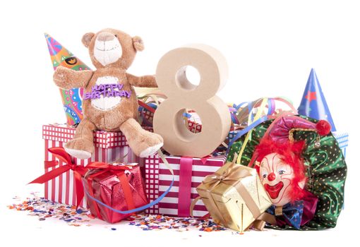 Number of age in a colorful studio setting with paper party hats, a red heart and gifts on a bottom of confetti for  childrens birthday party

