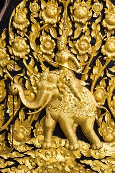 Laithai carved on the door at temple. Generality in Thailand, any kind of temple, art decorated in Buddhist church, temple etc. created with money donated by people to hire artist. They are public domain, no restrict in copy or use. This photo is taken under these conditions.