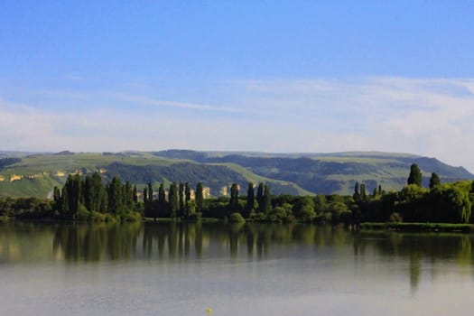 Calm lake and low mountains behind it