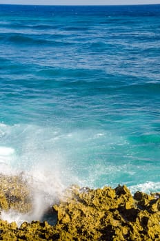 Blue and turquoise waves crashing against the shore in San Andres island, Colombia