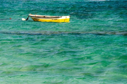 A boat in beautiful blue and turquoise Caribbean water in San Andres, Colombia