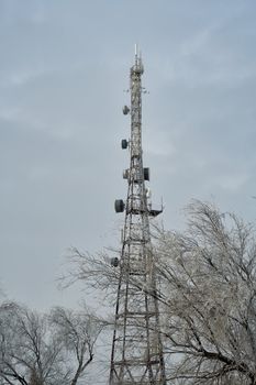 Tall steel lattice communications tower with antennae and radio dishes for sending and receiving signals for broadcasting and telecommunications