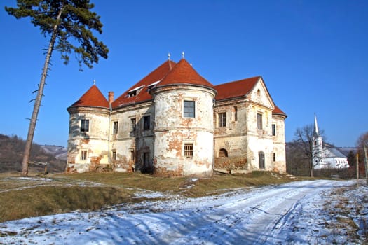 An old, crumbling manor house in the winter countyside