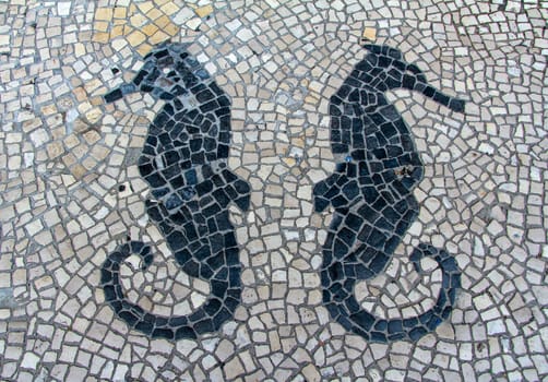 Clear stone blocks pavement texture with a dark central sea horses motive for background