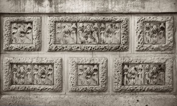 Detail of modernist flowers carving in stone wall rectangles
