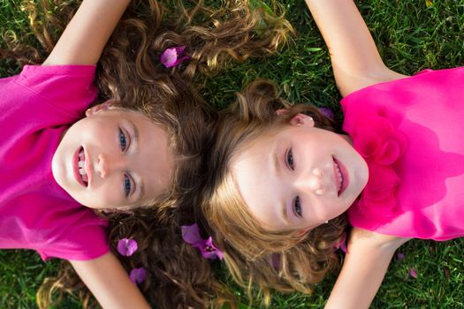 children friend girls lying together on garden grass smiling happy aerial view