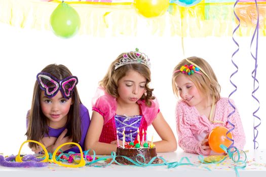 children happy girls blowing birthday party chocolate cake candles