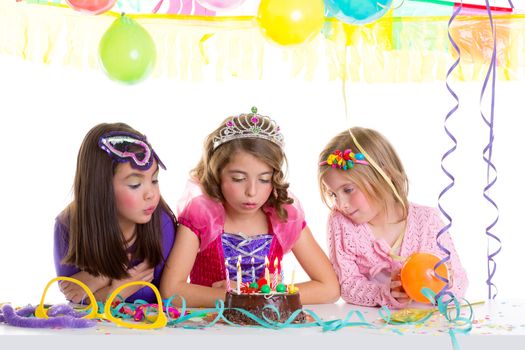 children happy girls blowing birthday party chocolate cake candles