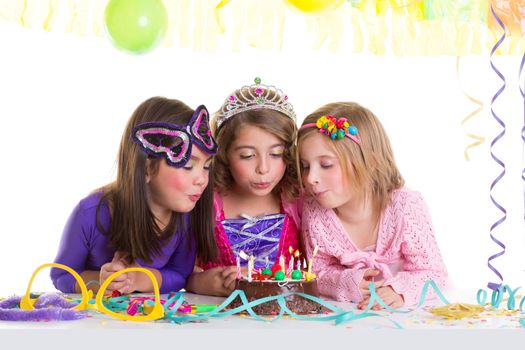 children happy girls blowing birthday party chocolate cake candles