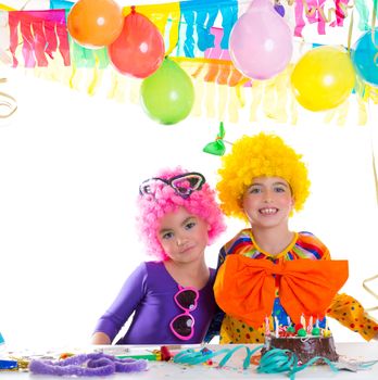 Children happy birthday party with clown wigs and chocolate cake
