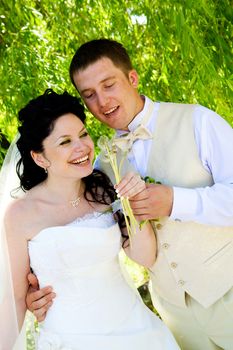 bride and groom blowing on the dandelions