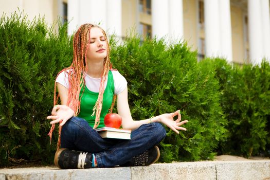 girl with a book meditating near the school
