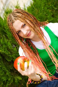 tennager girl with red apple on the green grass