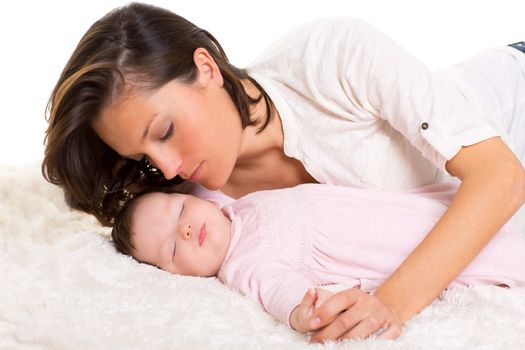 Baby girl sleeping with mother care near on white fur