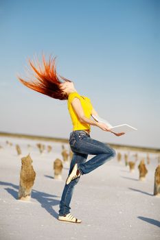 dancing girl with notebook in the desert