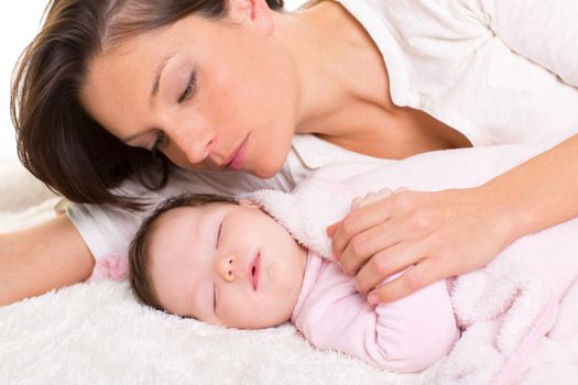 Baby girl sleeping with mother care near on white fur