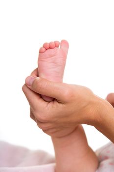 Mother hands holding baby nude foot on white background macro detail