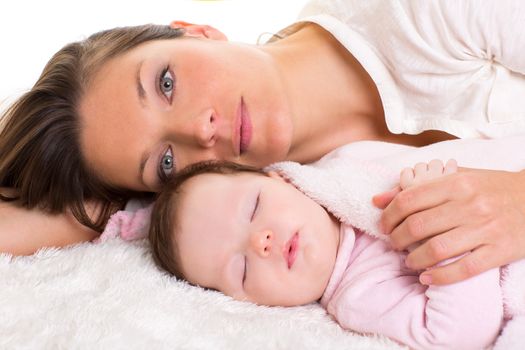 Baby girl sleeping with mother care near on white fur