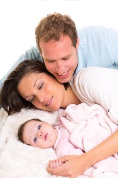 Baby girl mother and father family happy lying together on white fur