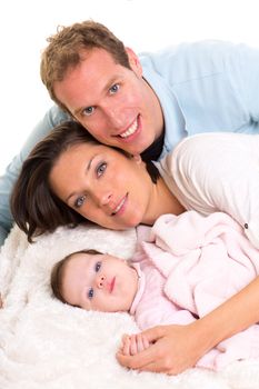 Baby girl mother and father family happy lying together on white fur