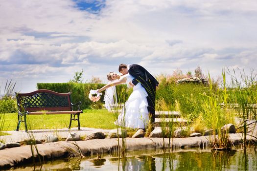 bride and groom kissing in the park