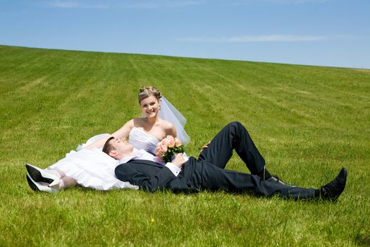 two happy people lay on the grass