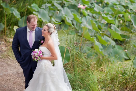 bride and groom near the lotus pond