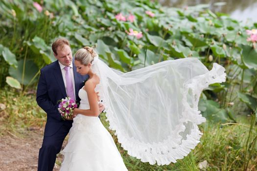 bride and groom near the lotus pond