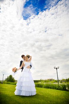 bride and groom kissing in the park