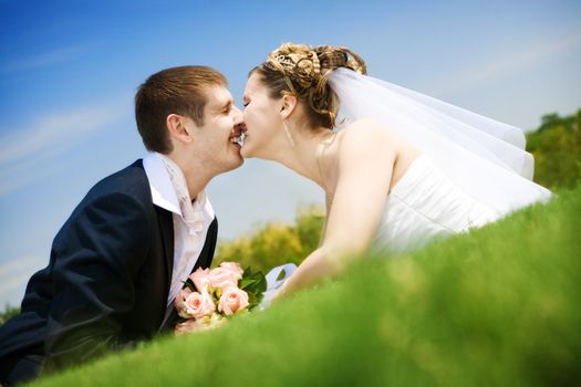 bride and groom kissing in the park