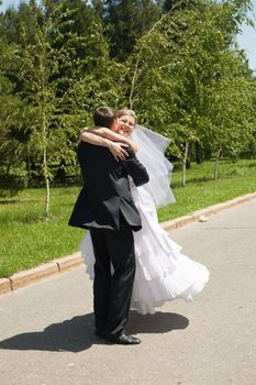 groom turning his bride on the road