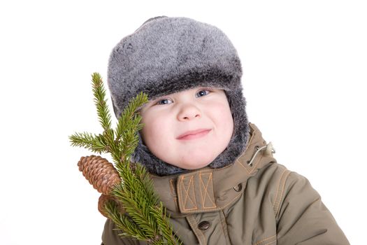 a smiling boy dressed for winter with a branch of fur tree with cones a smiling boy dressed for winter with a branch of fur tree with cones