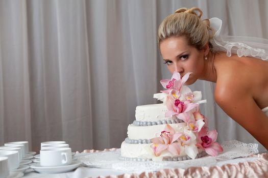 bride near a wedding cake with pink flowers