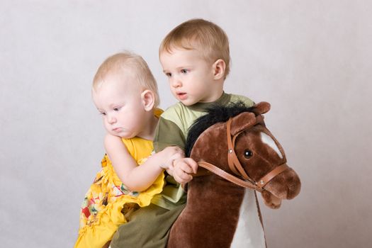two children playing with a toy horse together