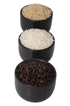 raw black, brown and white rice in bowls isolated on white backgrownd