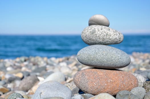 balancing stones on the beach against the sea