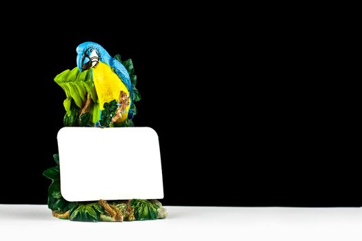 Close up picture of a parrot statue with a note 
