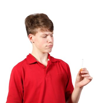 Thoughtful young boy looks at a cigarette