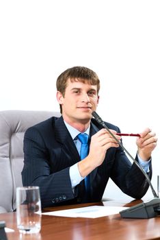 Portrait of a businessman sitting at a table and holding a pen