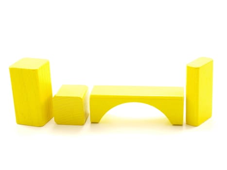 Wooden brick pieces of yellow color, isolated towards white