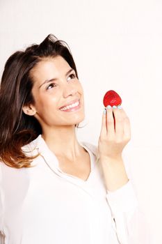 Portrait of a beautiful, latin Woman eating a Strawberry.