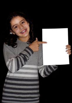 Cute child pointing at white card in a black background