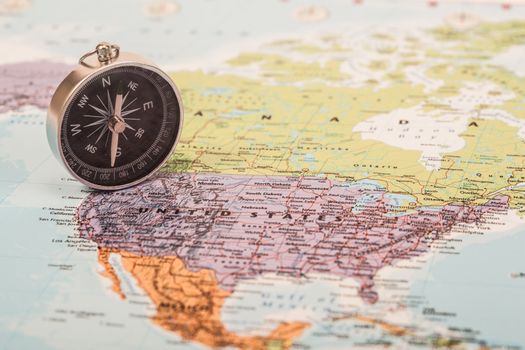 A photograph with shallow depth of field of a black compass on a map, with selective focus.