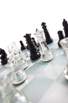 Black and transparent glass chess pieces, on a see through chessboard.