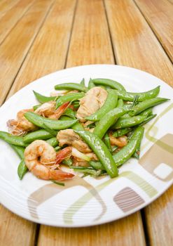 Thai-food Fried shrimp, pork and sweet peas. wood background.